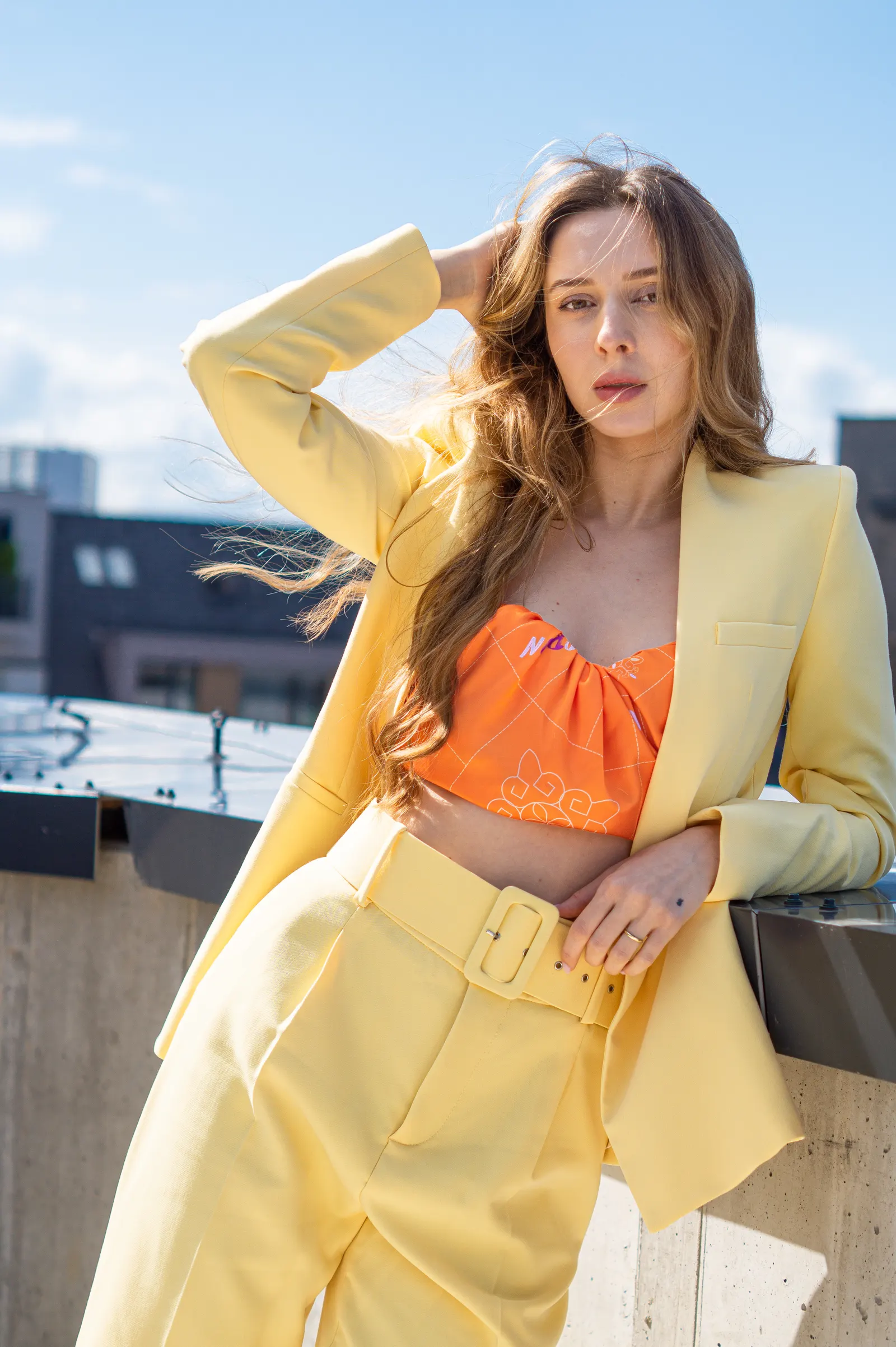 Editorial fashion shot — yellow suit on a Bratislava rooftop
